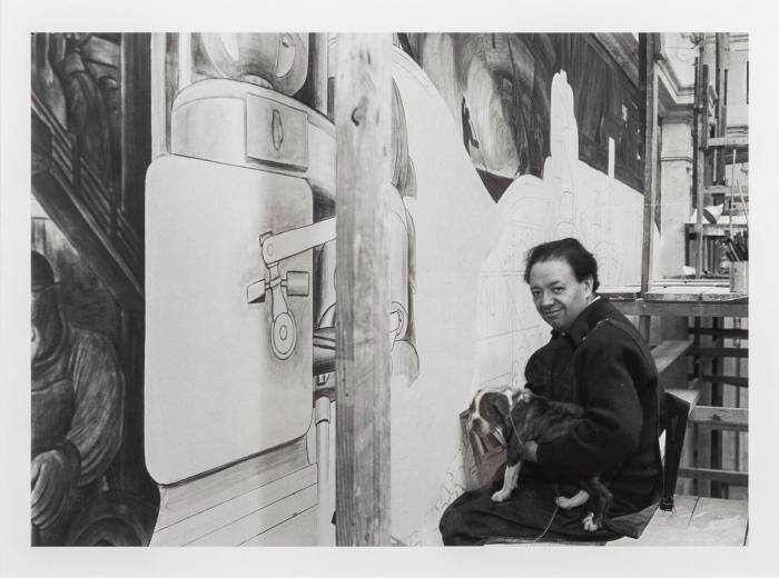 Black and white reproduction of a photograph of Diego Rivera painting a mural in Detroit.